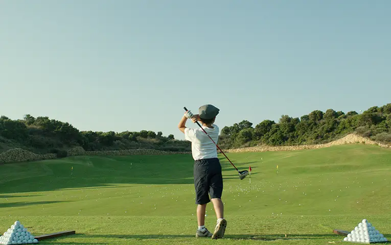 A kid is playing golf at Costa Navarino